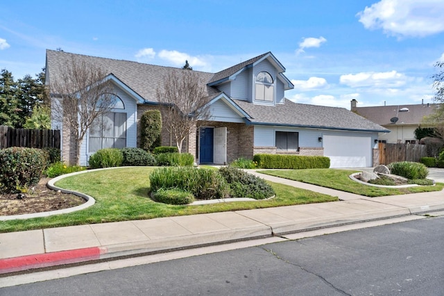 view of front of home featuring brick siding, an attached garage, fence, and a front yard