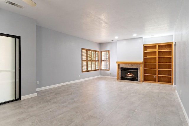 unfurnished living room with recessed lighting, a glass covered fireplace, visible vents, and baseboards