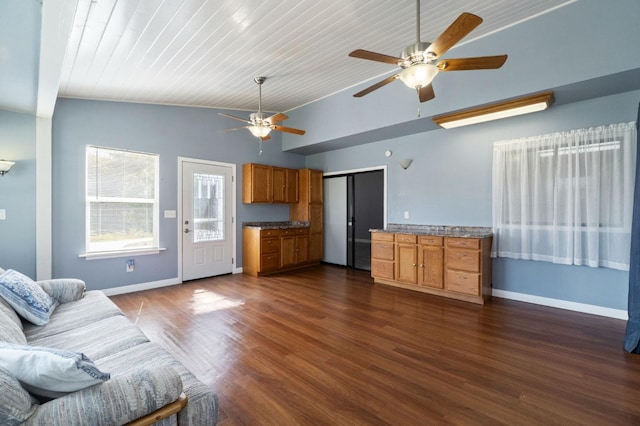 living area featuring lofted ceiling, dark wood finished floors, baseboards, and ceiling fan