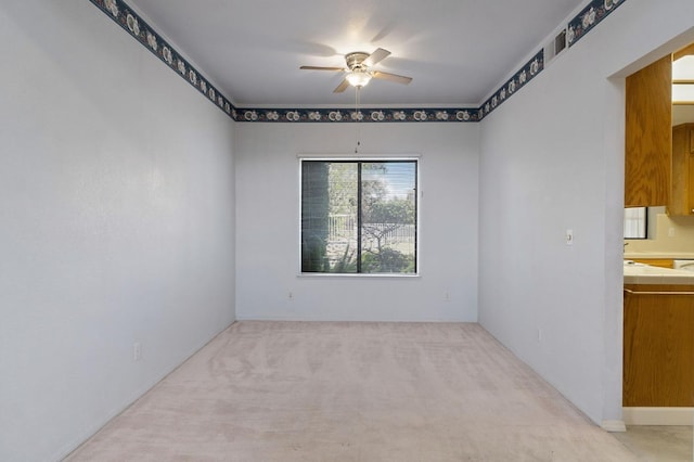 carpeted empty room featuring a ceiling fan