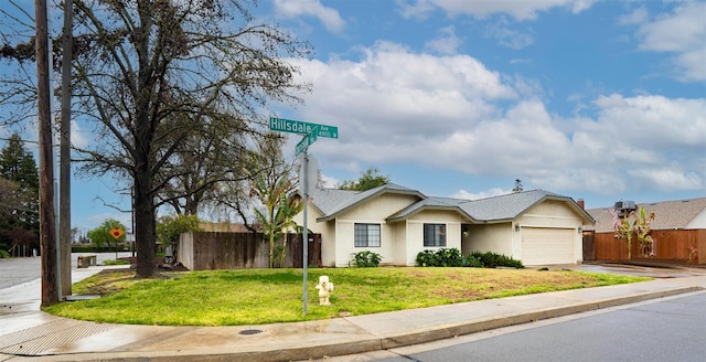 ranch-style house with stucco siding, concrete driveway, fence, a garage, and a front lawn