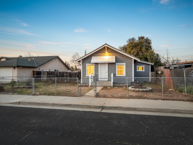 bungalow with a fenced front yard and a gate