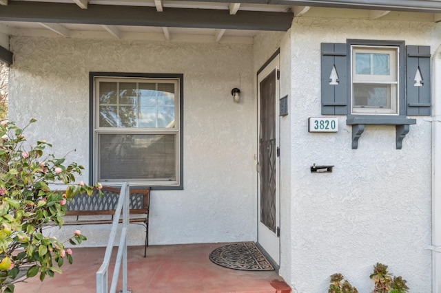 property entrance with stucco siding