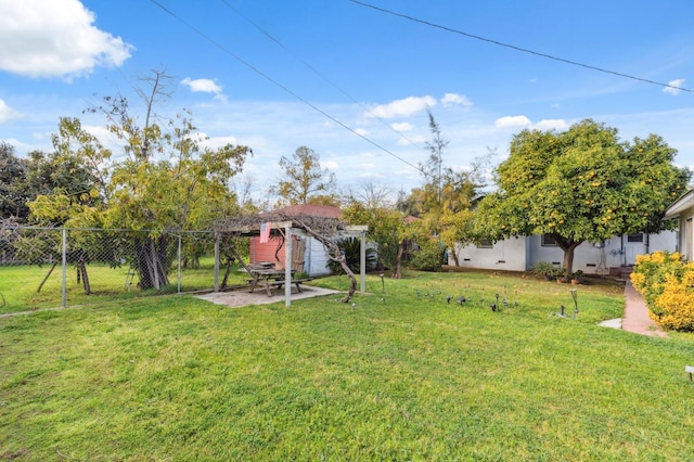 view of yard featuring a patio area, an outdoor structure, and fence