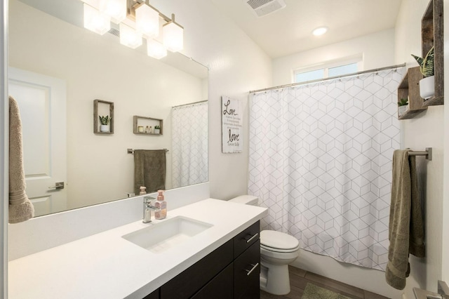 bathroom featuring toilet, shower / bath combo with shower curtain, vanity, and visible vents