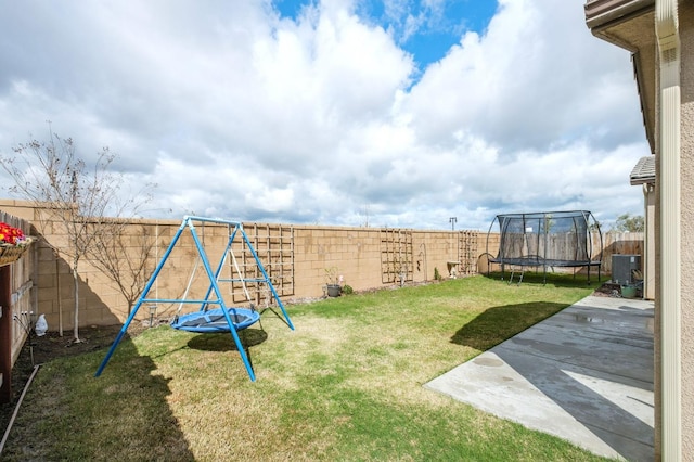 view of yard featuring a fenced backyard, a trampoline, a playground, and a patio