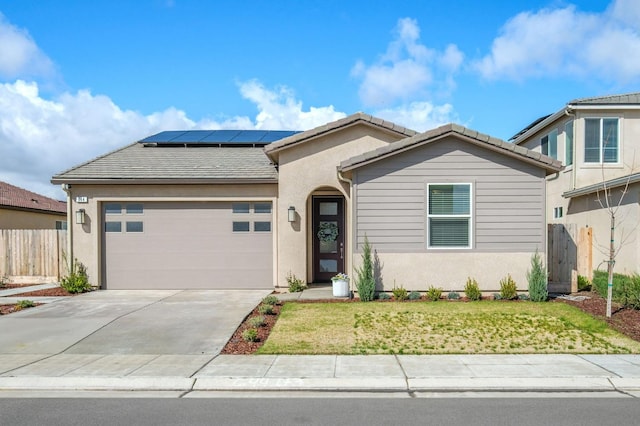 ranch-style house with a garage, a tile roof, roof mounted solar panels, and fence