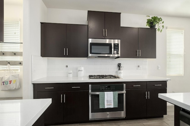 kitchen featuring backsplash, stainless steel appliances, and light countertops