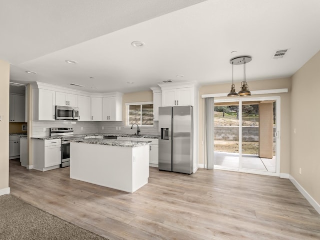 40023 Woodsong Way, Oakhurst, CA 93644 - kitchen with visible vents, appliances with stainless steel finishes, tasteful backsplash, and a wealth of natural light
