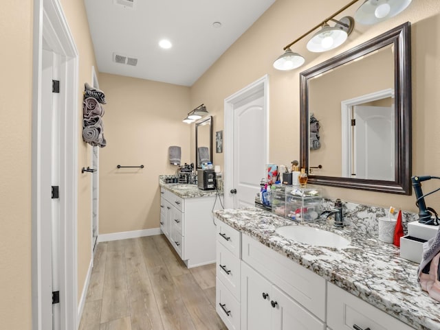 40023 Woodsong Way, Oakhurst, CA 93644 - bathroom with baseboards, visible vents, wood finished floors, a sink, and two vanities