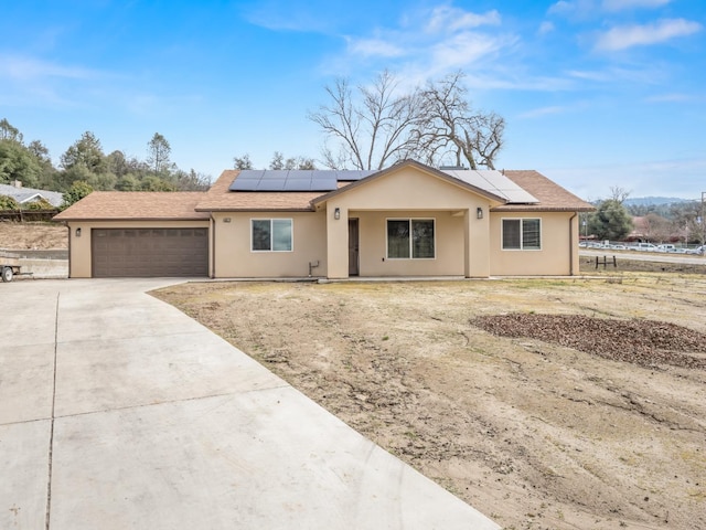 40023 Woodsong Way, Oakhurst, CA 93644 - ranch-style house featuring driveway, a garage, solar panels, and stucco siding