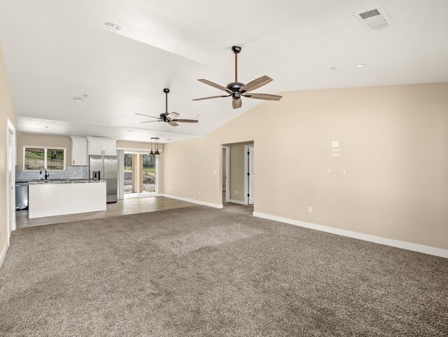 40023 Woodsong Way, Oakhurst, CA 93644 - unfurnished living room with lofted ceiling, light carpet, a sink, visible vents, and baseboards
