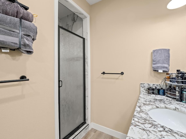 40023 Woodsong Way, Oakhurst, CA 93644 - full bath featuring a stall shower, a sink, baseboards, and wood finished floors