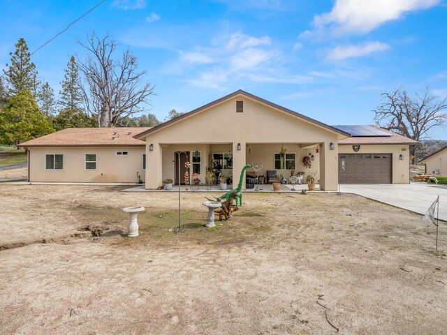 40023 Woodsong Way, Oakhurst, CA 93644 - single story home featuring driveway, stucco siding, an attached garage, and roof mounted solar panels
