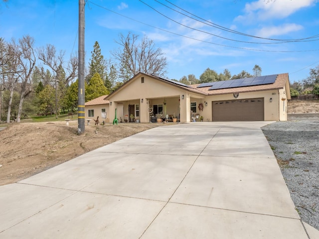 40023 Woodsong Way, Oakhurst, CA 93644 - view of front facade with a garage, concrete driveway, stucco siding, and roof mounted solar panels