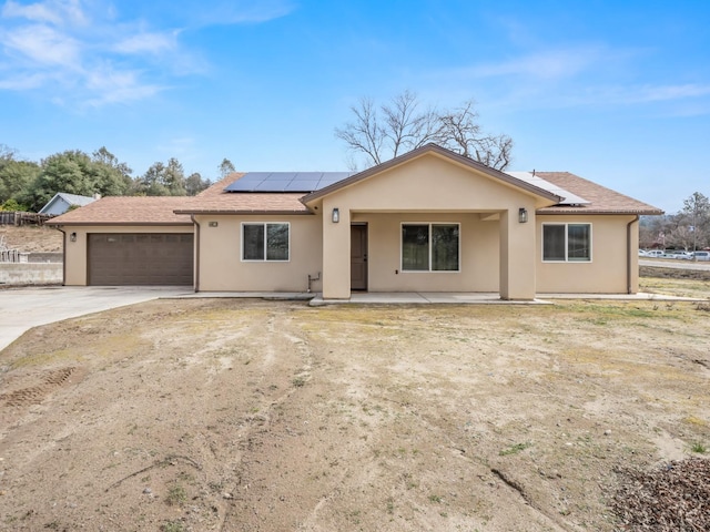 40023 Woodsong Way, Oakhurst, CA 93644 - ranch-style house featuring driveway, a garage, a shingled roof, roof mounted solar panels, and stucco siding