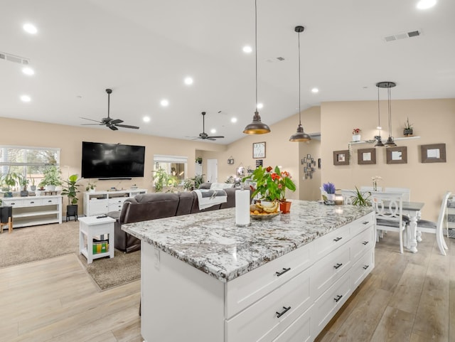 40023 Woodsong Way, Oakhurst, CA 93644 - kitchen featuring light wood-style floors, a center island, white cabinets, and visible vents