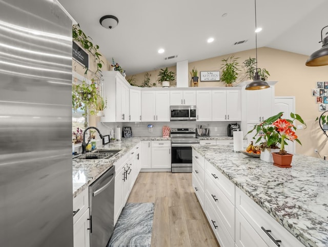 40023 Woodsong Way, Oakhurst, CA 93644 - kitchen with lofted ceiling, visible vents, appliances with stainless steel finishes, light wood-style floors, and a sink