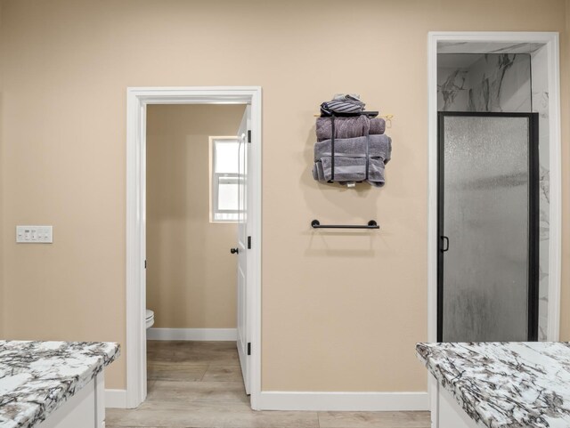 40023 Woodsong Way, Oakhurst, CA 93644 - full bathroom featuring toilet, wood finished floors, vanity, baseboards, and a stall shower