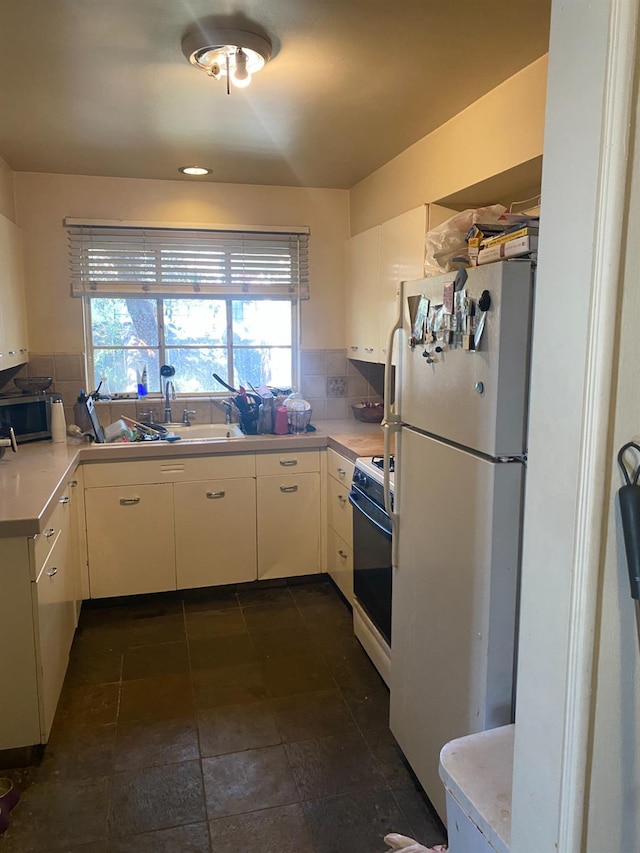 kitchen with light countertops, white appliances, backsplash, and white cabinets