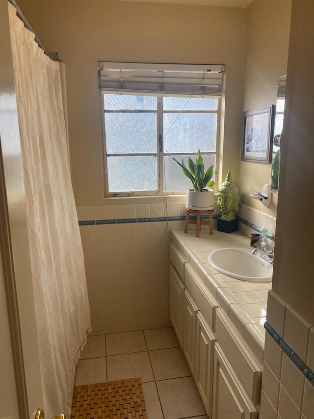 bathroom with curtained shower, tile patterned flooring, a wainscoted wall, vanity, and tile walls