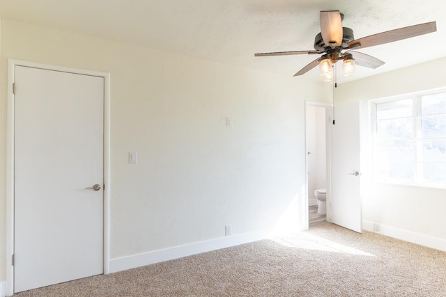 spare room featuring a ceiling fan, carpet flooring, and baseboards