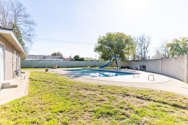 view of swimming pool with a fenced in pool, a yard, a patio, a water slide, and a fenced backyard