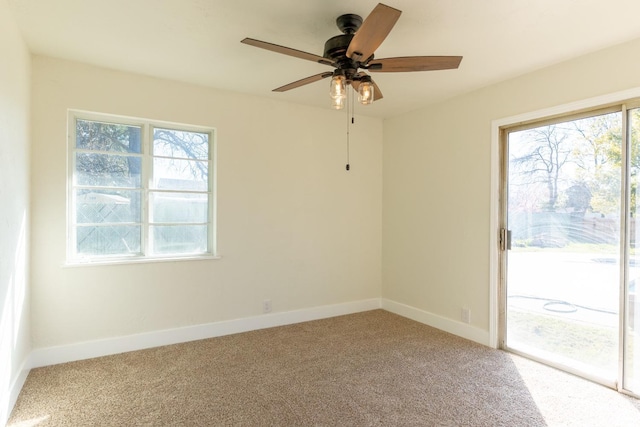 carpeted empty room featuring plenty of natural light and baseboards