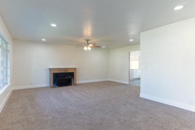 unfurnished living room featuring carpet, a fireplace, baseboards, and recessed lighting