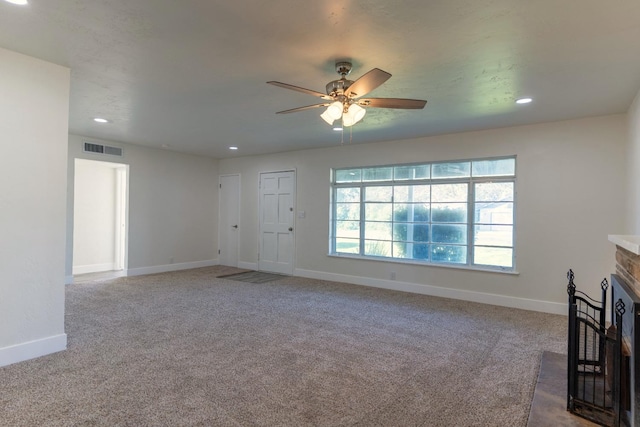 unfurnished living room with visible vents, baseboards, a fireplace with flush hearth, carpet floors, and recessed lighting