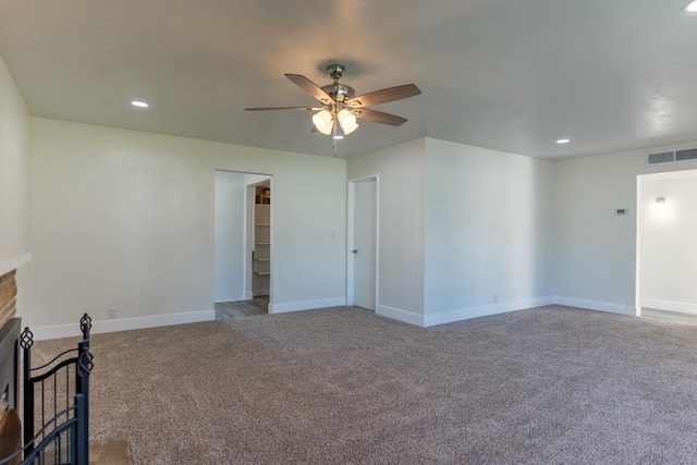 empty room with recessed lighting, a fireplace, visible vents, baseboards, and carpet