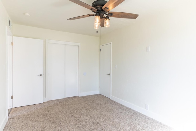 unfurnished bedroom with ceiling fan, a closet, baseboards, and carpet flooring