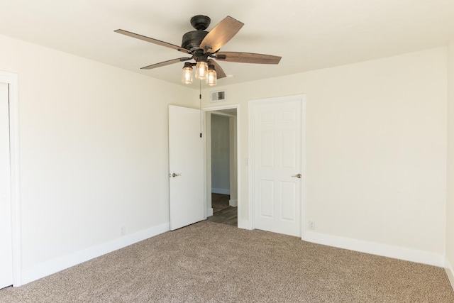 unfurnished bedroom with a ceiling fan, carpet flooring, visible vents, and baseboards