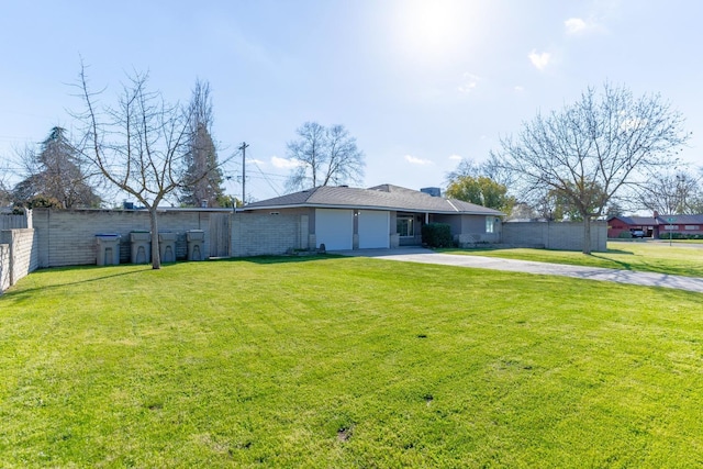 view of yard featuring a garage, driveway, and fence