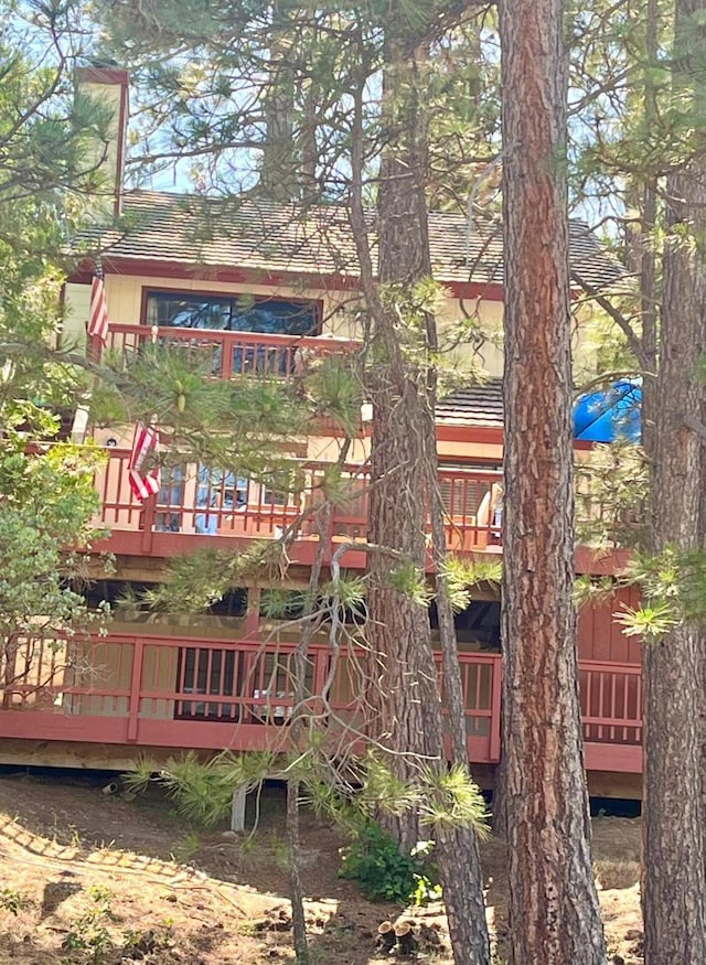 back of house featuring a tile roof and a wooden deck