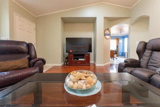 living area with lofted ceiling, ornamental molding, arched walkways, and wood finished floors