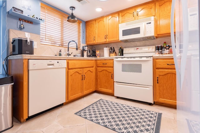 kitchen featuring white appliances, light tile patterned floors, tile counters, and decorative backsplash