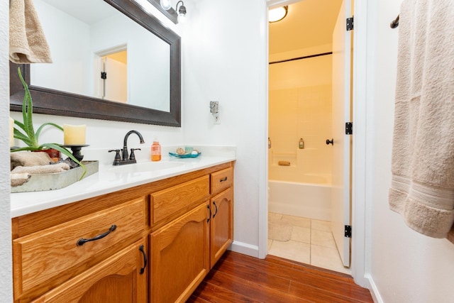 bathroom with shower / washtub combination, vanity, baseboards, and wood finished floors