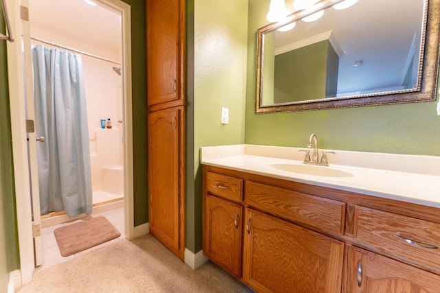 full bathroom with a stall shower, vanity, and baseboards