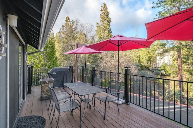 deck featuring outdoor dining space and a grill