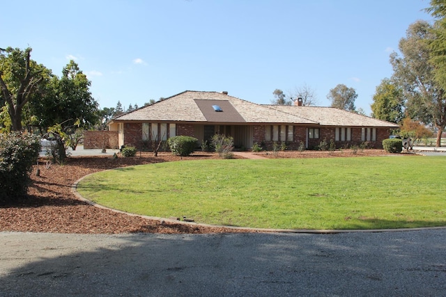 ranch-style home with a front yard and brick siding