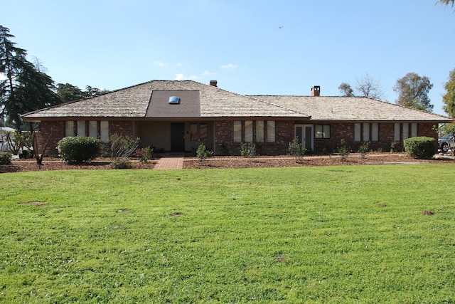 ranch-style home featuring brick siding and a front lawn