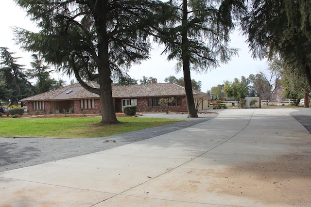 single story home with brick siding and a front lawn