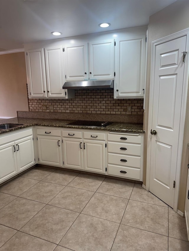 kitchen featuring light tile patterned floors, tasteful backsplash, white cabinetry, and under cabinet range hood