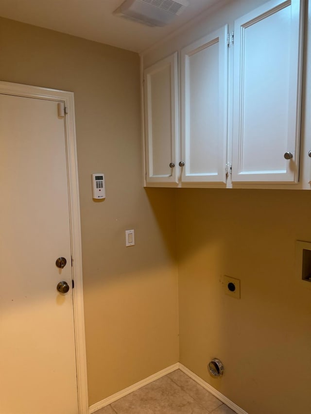 clothes washing area featuring cabinet space, light tile patterned floors, baseboards, visible vents, and hookup for an electric dryer