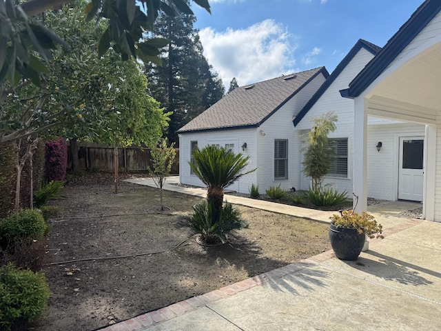 view of side of property with a patio area and fence