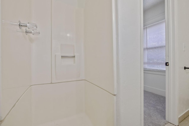 full bath featuring baseboards and walk in shower