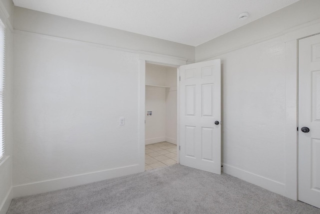 unfurnished bedroom featuring baseboards and light colored carpet