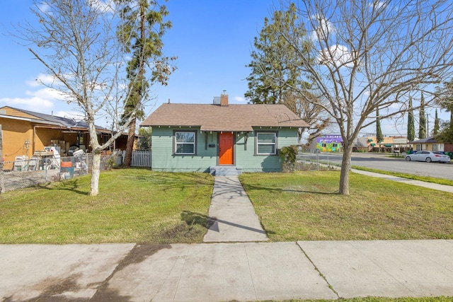 bungalow-style house featuring a front lawn, a chimney, and fence