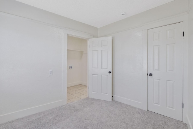 unfurnished bedroom featuring baseboards and light colored carpet